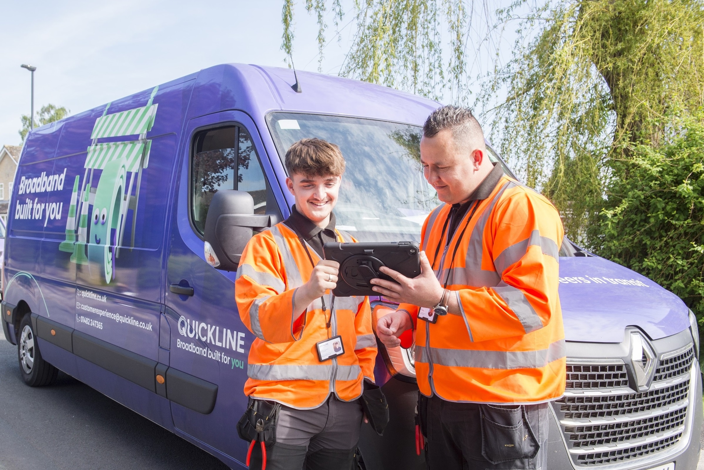 Two Quickline workers stood in front of a van